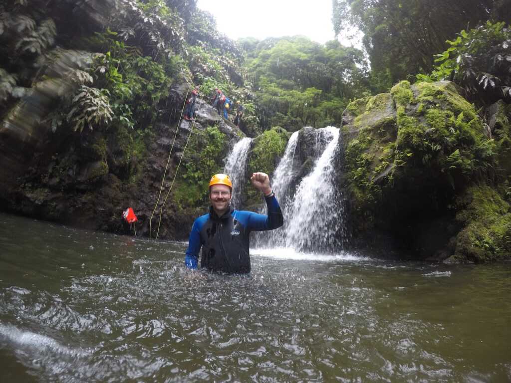 Autor Daniel Herold im Wasser nach dem Abseilen am Wasserfall beim Canyoning auf den Azoren 